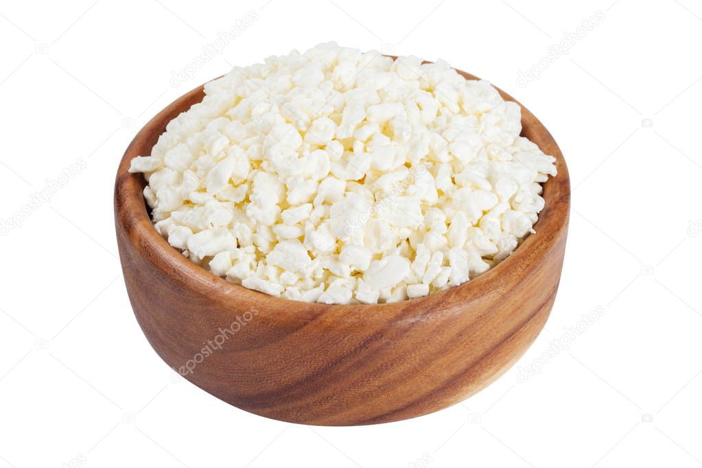 Cottage cheese in rustic wooden bowl, isolated on white. 