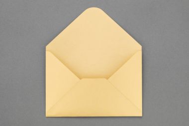 Gri arka plan üzerine açık sarı kağıt zarf.