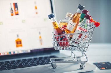 Minsk, Beyaz Rusya - 16 Ocak 2018: mini alışveriş sepeti küçük alkol şişeleri - Jameson viski, Camus ve Martell konyak, Havana club ROM, Beefeater cin dizüstü bilgisayar arka plan üzerinde dolu. Minsk, Beyaz Rusya.