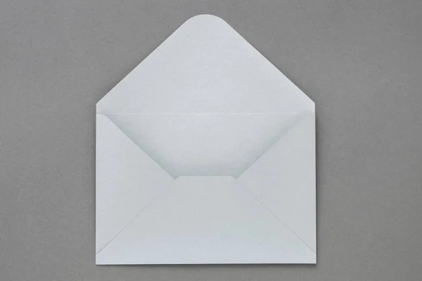 Offener grauer Umschlag auf dunkelgrauem Hintergrund. — Stockfoto