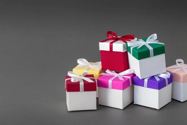 Geschenkboxen mit Bändern auf grauem Hintergrund. Kopierraum für Text. — Stockfoto