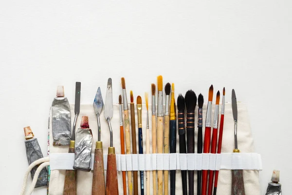 Verfborstels, palet messen en verf buizen in textiel draagtas. Een opbergtas gevuld voor tools voor professioneel kunstenaar werk. Ruimte voor tekst kopiëren. — Stockfoto