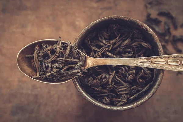 Coupe en métal vintage de feuilles de thé vert sec et cuillère. Vue du dessus . — Photo