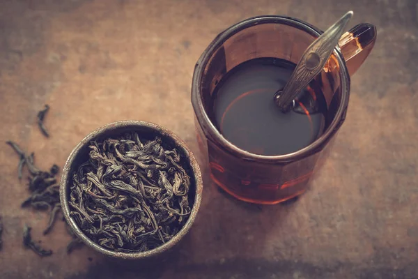 Vintage-Tasse Tee und rustikale Metalltasse mit trockenen Teeblättern. — Stockfoto
