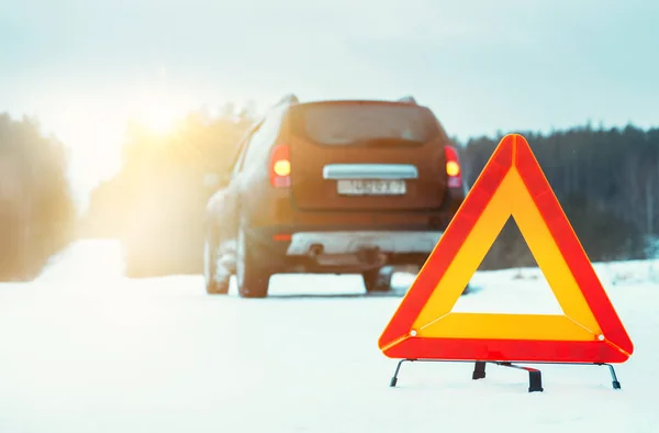 Sürgősségi stoptábla és autó téli úton naplementekor. — Stock Fotó
