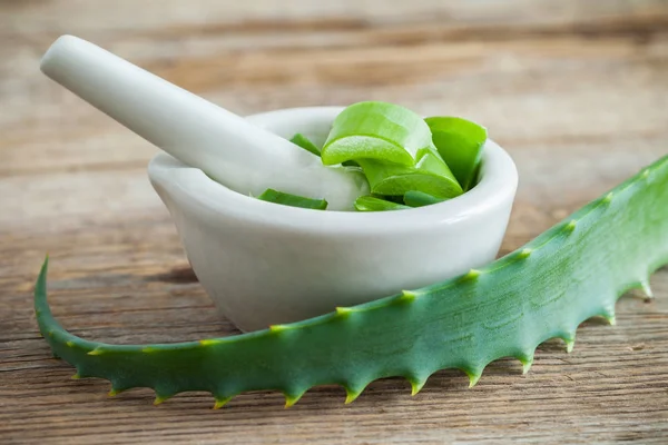 Groene Aloë vera blad en mortel vol met gehakte Aloë. — Stockfoto