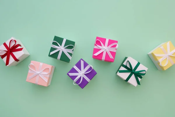 Gift boxes with ribbons on pastel green background. Top view, flat lay. Copy space for text. — Stock Photo, Image