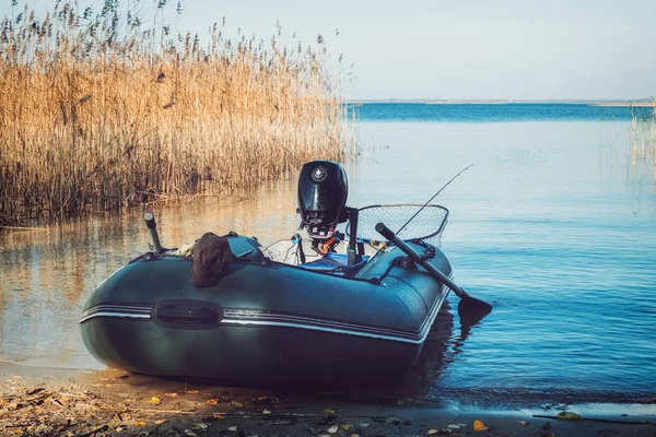 Gumová rybářská loď na klidném břehu jezera. — Stock fotografie