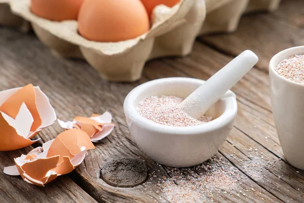 Mortel av krossat äggskal, pappkartong med ägg. Hela och pulveriserade äggskal, naturligt kalcium, näringsämne produkt. — Stockfoto