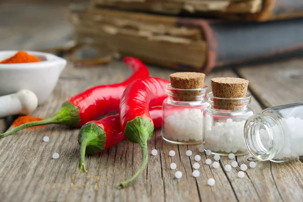 Rode chili peper en flessen homeopathische bolletjes. Homeopathie. — Stockfoto