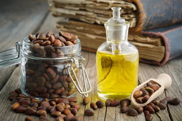 Pine nuts and pine nuts essential oil bottle on table. — 스톡 사진