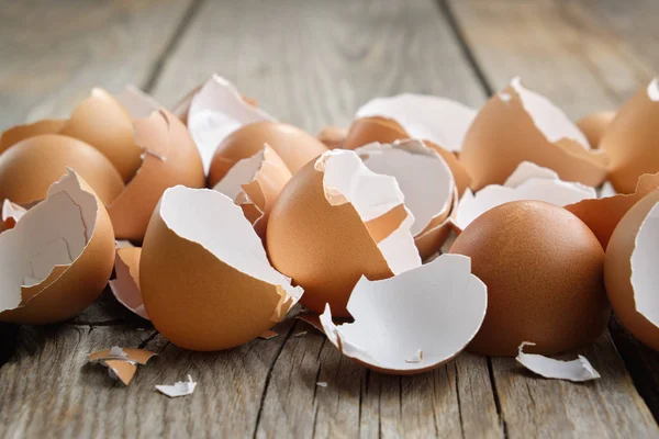 Vaječná skořápka. Shell of eggs on wooden kitchen table. — Stock fotografie