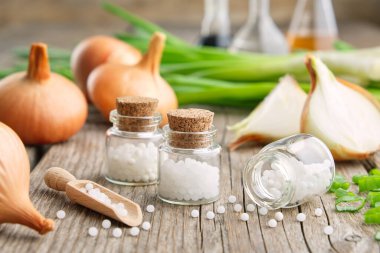 Bir şişe homeopatik küre, soğan soğanı ve taze taze soğan. Allium cepa homeopatik tedaviler.