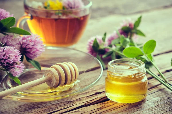 テーブルの上に蜂蜜のためのクローバーの花 ハーブティーカップ 蜂蜜瓶と木製のディップ — ストック写真