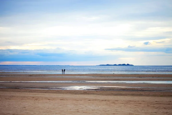 Dos personas en la playa de arena en tiempo nublado —  Fotos de Stock