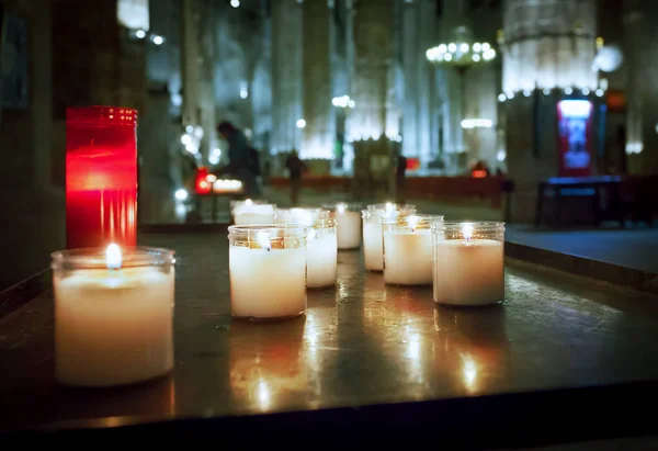 Red and white candles in the old gothic church and visitors on b — Stock Photo, Image