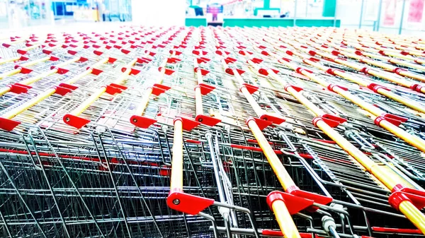 Fileiras de carrinhos de compras no salão de compras do supermercado — Fotografia de Stock
