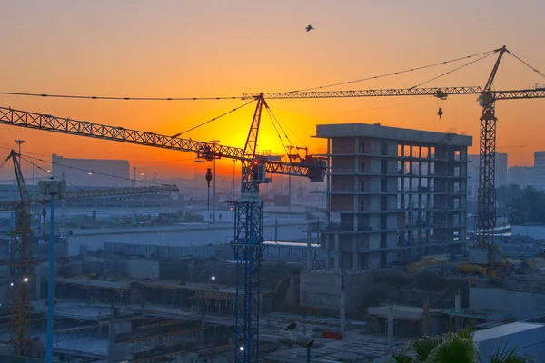 Uma cena de canteiro de obras com guindastes à noite — Fotografia de Stock