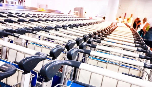 Řady zavazadlových vozíků v hale letištního terminálu — Stock fotografie
