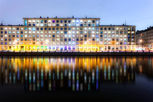 Een avond uitzicht op kleurrijke ramen van meergezinswoningen met de — Stockfoto
