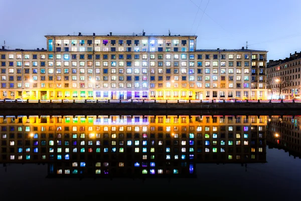 Une vue de nuit des fenêtres colorées des maisons multifamiliales avec le — Photo