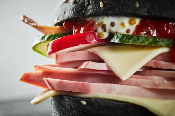 Hambúrguer com presunto e pão preto — Fotografia de Stock