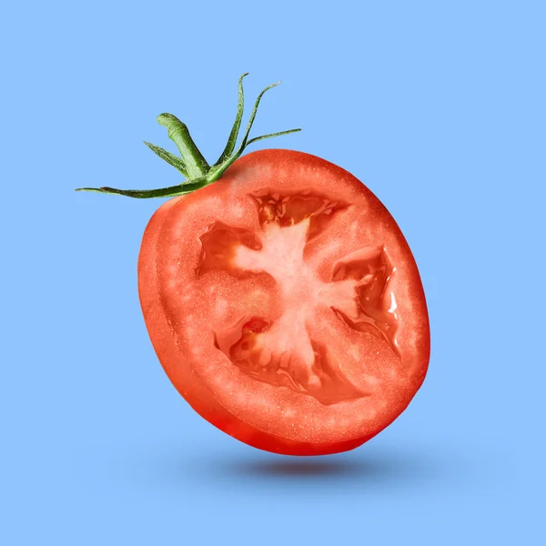 Halbe Tomate vor blauem Hintergrund — Stockfoto