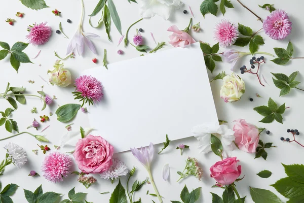 Λουλούδια με άδειο λευκό σημειωματάριο — Φωτογραφία Αρχείου