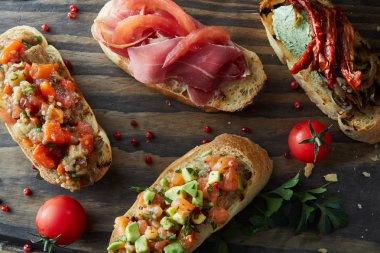 Közlenmiş domates, avokado, somon, jambon, biber, bitki ile İtalyan bruschetta