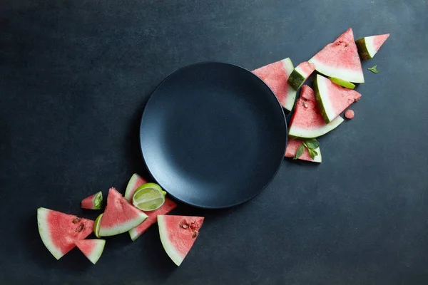 Scheiben Wassermelone und schwarzer Teller — Stockfoto