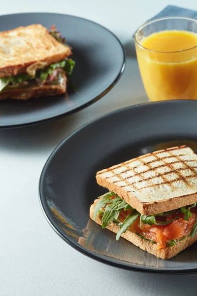 Sandwiches on plates and fresh juice — Stock Photo, Image