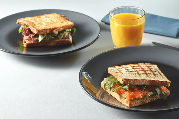 Sandwiches on plates and fresh juice — Stock Photo, Image