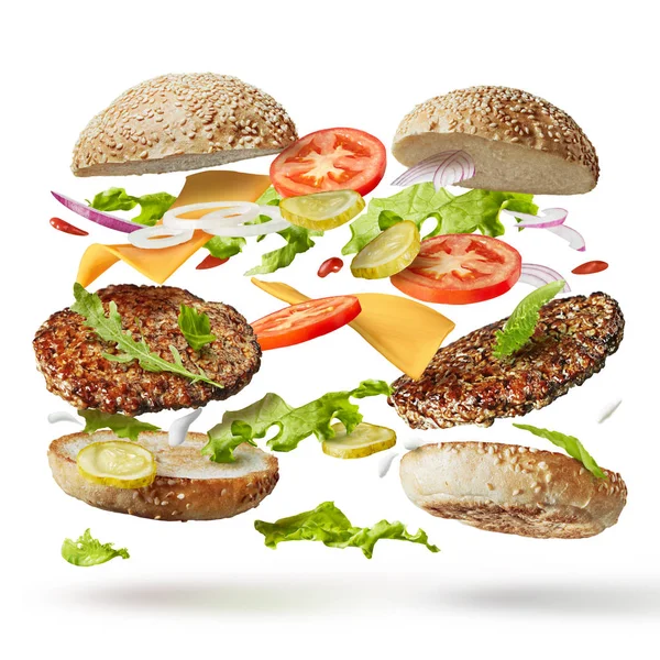 Burger ze składnikami latającymi — Zdjęcie stockowe