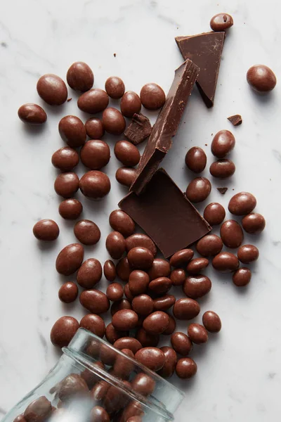 Bolas de chocolate dispersas del frasco de vidrio —  Fotos de Stock