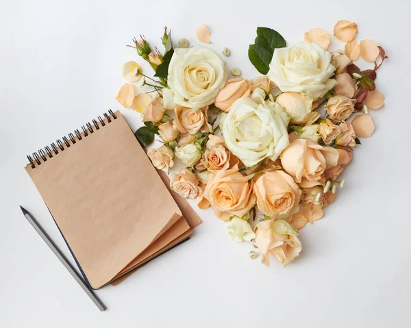 Cabezas de rosas en forma de corazón y bloc de notas —  Fotos de Stock