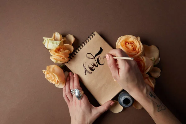 Nő írás szeretet jele a Jegyzettömbben — Stock Fotó
