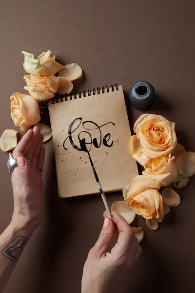 Жінка пише знак любові в блокноті — стокове фото