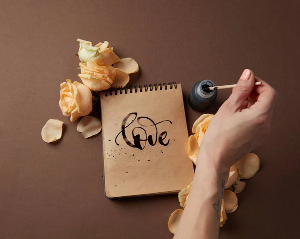 Γυναίκα γράφοντας αγάπη σημάδι στο Σημειωματάριο (Notepad) — Φωτογραφία Αρχείου