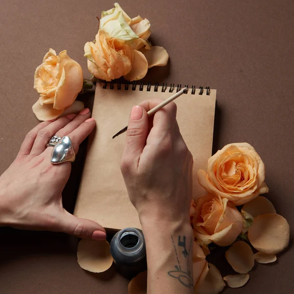 Mujer escribiendo en bloc de notas artesanal — Foto de Stock