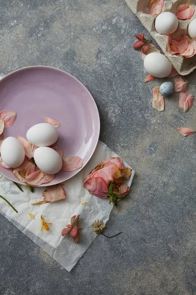 Huevos en plato con pétalos de flores — Foto de Stock