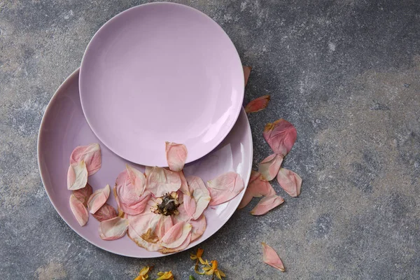 Getrocknete Blütenblätter auf rosa Tellern — Stockfoto