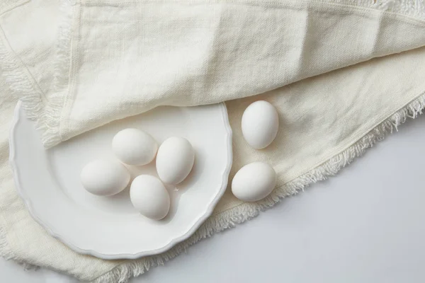 Raw eggs on white plate — Stock Photo, Image