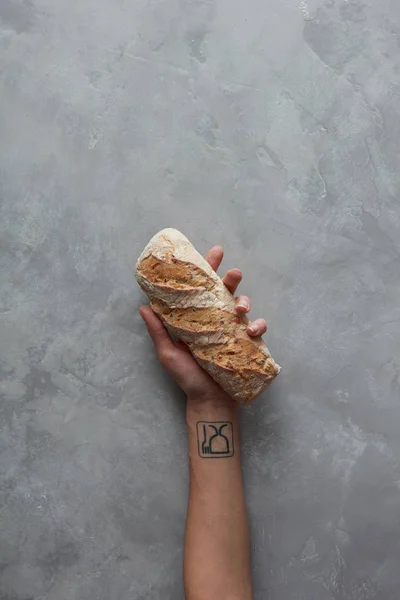 Женщина держит буханку хлеба за руку — стоковое фото