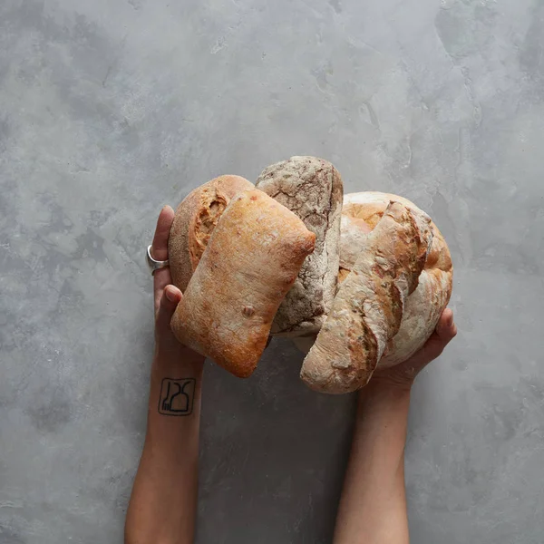 Handen van Bakker houdt zorgvuldig loafs — Stockfoto