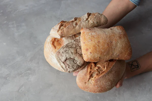 Mãos de padeiro cuidadosamente segurar loafs — Fotografia de Stock