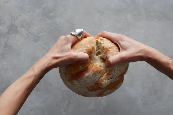 Руки женщины преломляют хлеб — стоковое фото