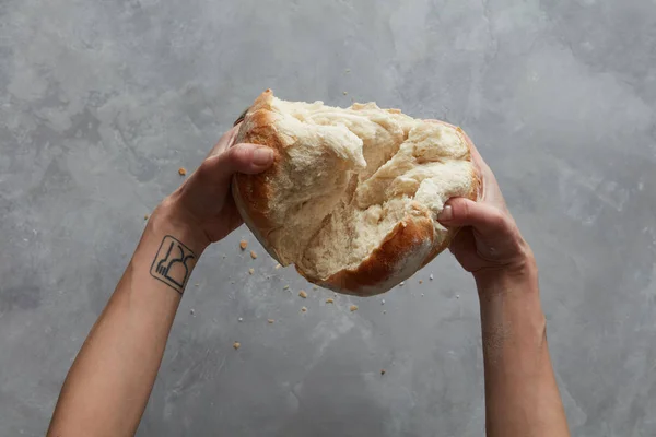 Vrouwelijke handen breken brood — Stockfoto