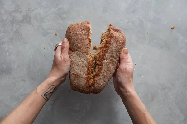 Руки женщины преломляют хлеб — стоковое фото