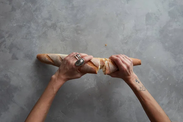 Vrouwelijke handen breken brood — Stockfoto