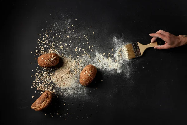 Hand sweeping flour with brush — Stock Photo, Image